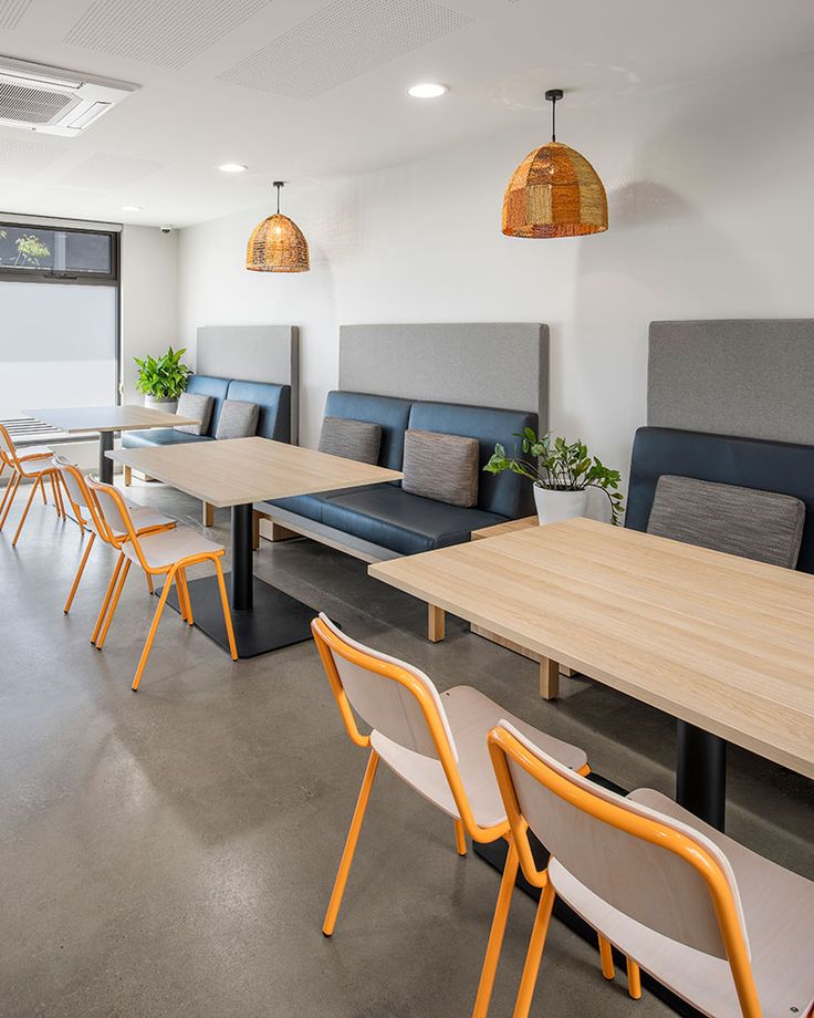 an empty conference room with blue and yellow chairs, tables and couches on the floor