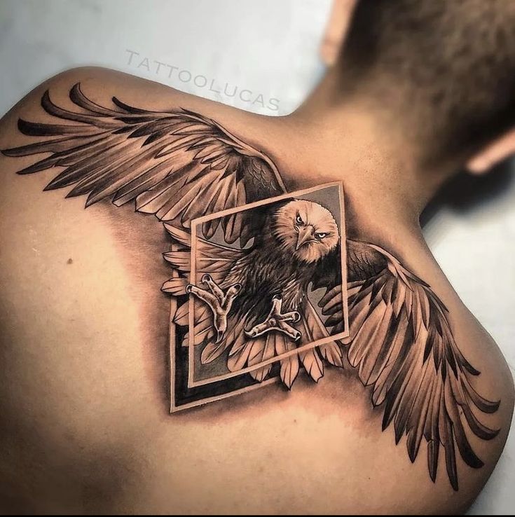 an eagle tattoo on the back of a man's shoulder