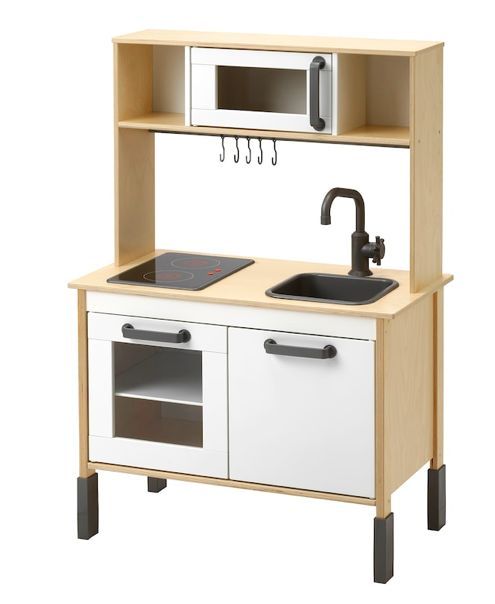 a wooden play kitchen with sink, stove and microwave on the shelf over it's sink