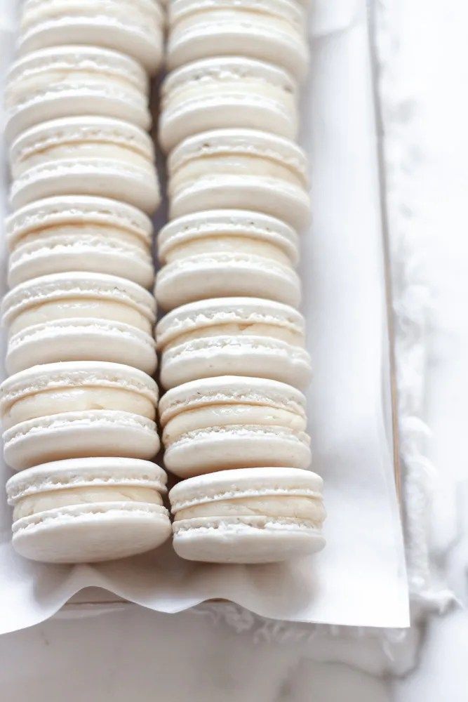 a white plate topped with macaroons covered in frosting