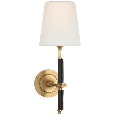 a wall light with a white shade on the side and a black pole attached to it