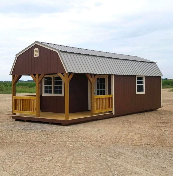 a small brown building sitting on top of a dirt field