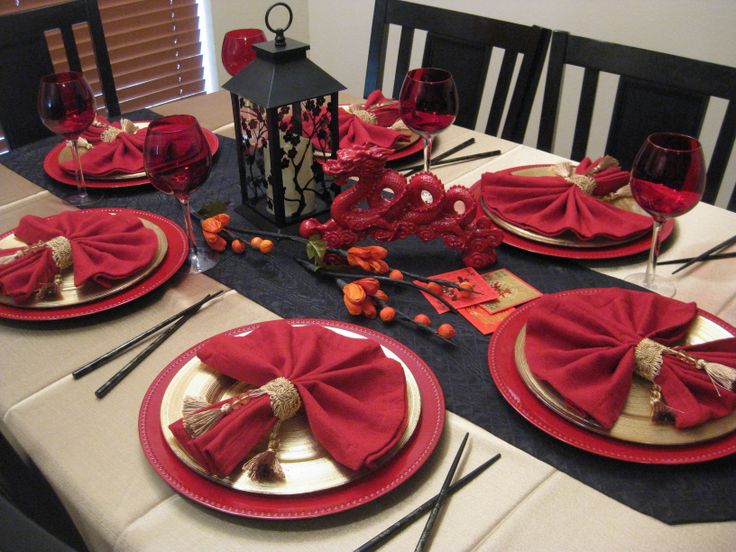 the table is set with red napkins and place settings