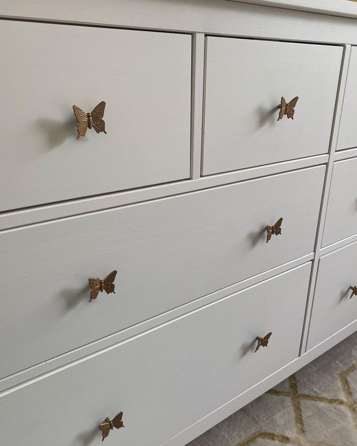 a white dresser with gold butterflies on it