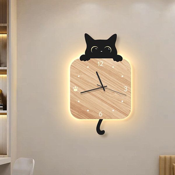 a wooden clock with a black cat on it's face is lit up in the room