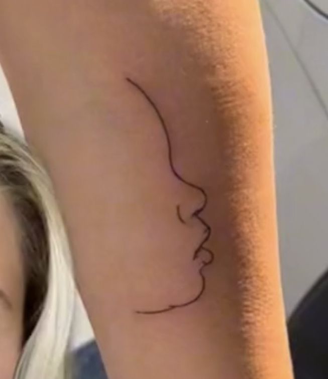 a woman's arm with a tattoo on it that is shaped like a face