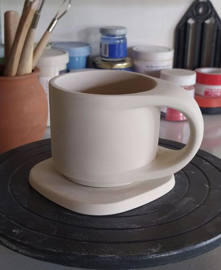 a white coffee cup sitting on top of a table