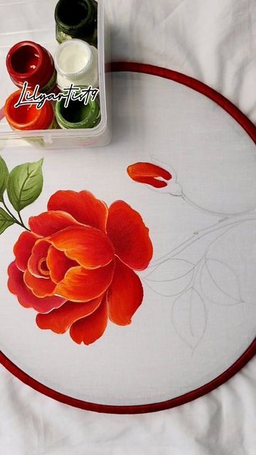 a white table topped with a red and green flower painted on top of it's surface