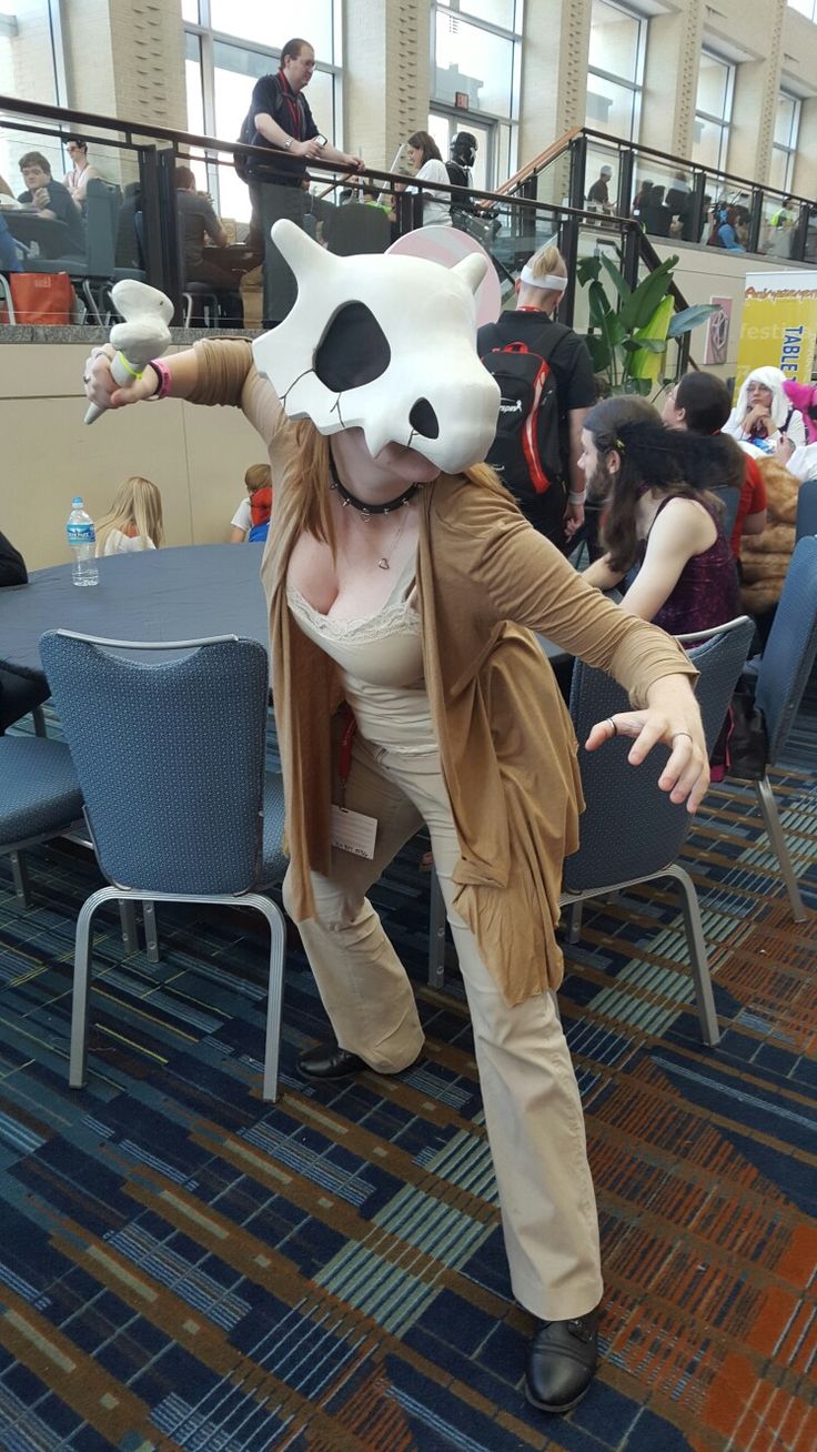 a woman dressed as a raccoon poses for a photo in an office setting