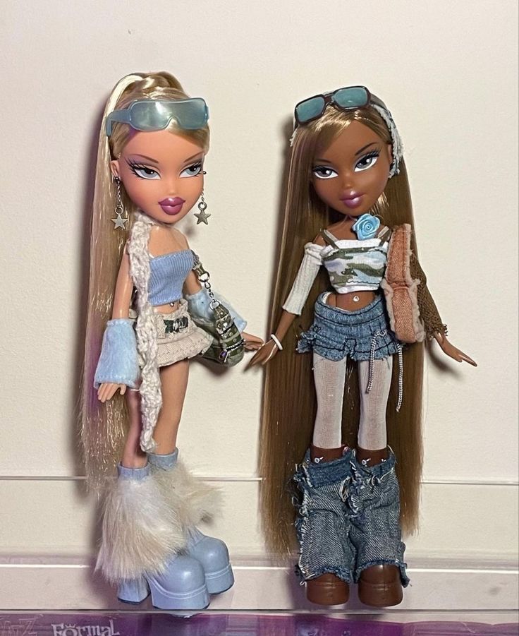 two dolls are standing next to each other