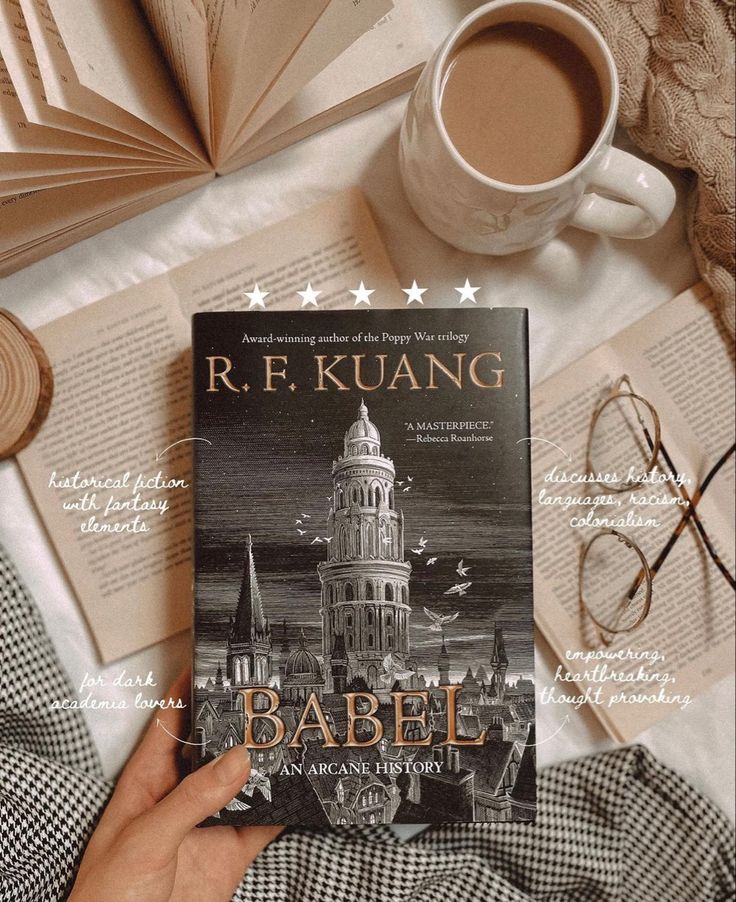 the book babel by r r kuang is in front of a cup of coffee