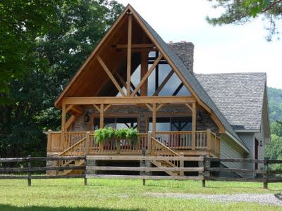 a large wooden house sitting on top of a lush green field