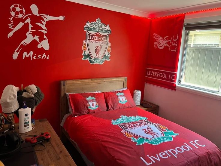 a bedroom decorated in red and white with liverpool wall decals