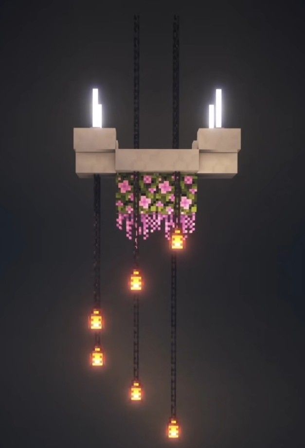 a bunch of lights that are on some kind of pole in the dark with flowers hanging from it