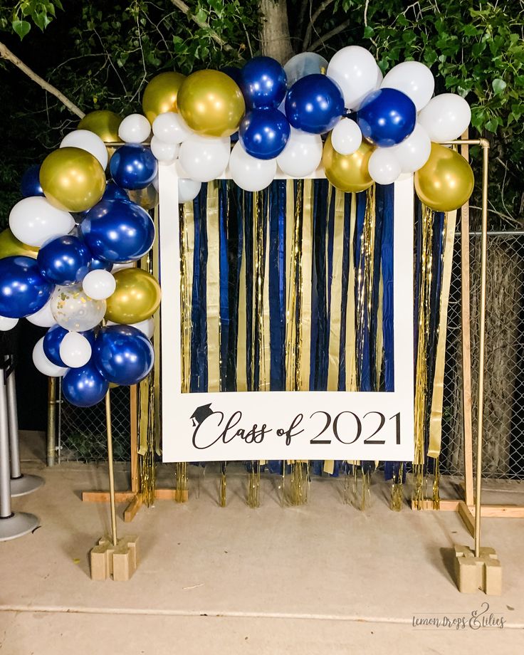 a photo frame with balloons and streamers in front of a sign that reads class of 2021