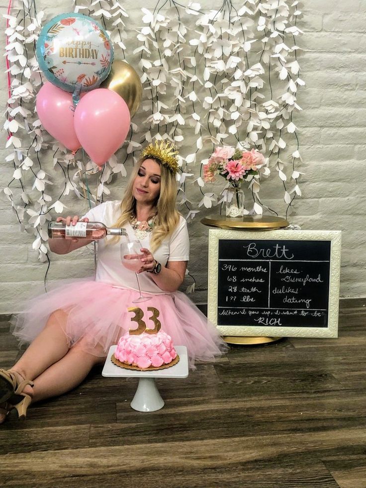 a woman sitting in front of a birthday cake