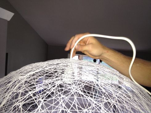 a person is holding a white wire ball