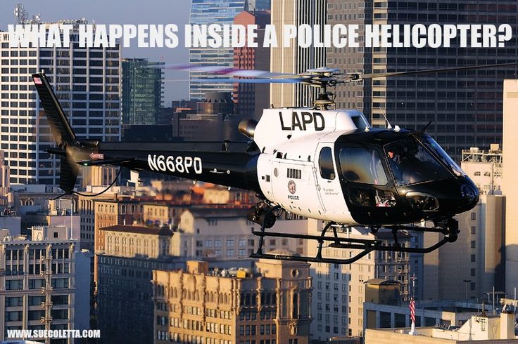 a helicopter flying over a city with tall buildings