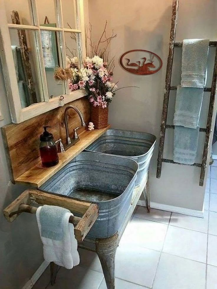 a bathroom with two sinks and towels on the rack in front of the sink is a ladder