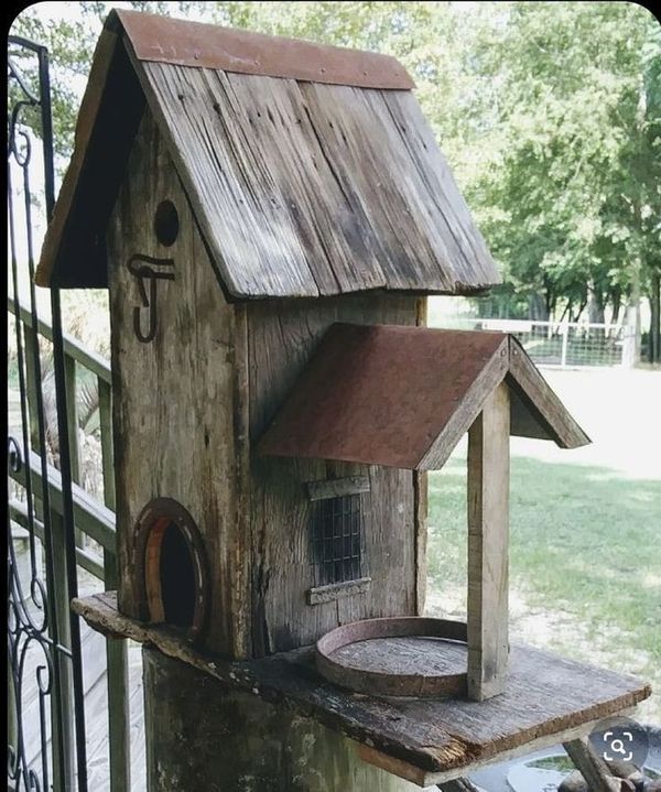 a wooden birdhouse with a metal roof