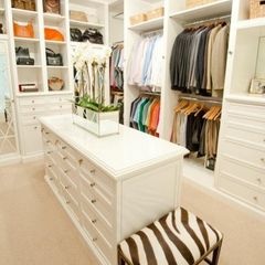 an organized closet with white cabinets and drawers