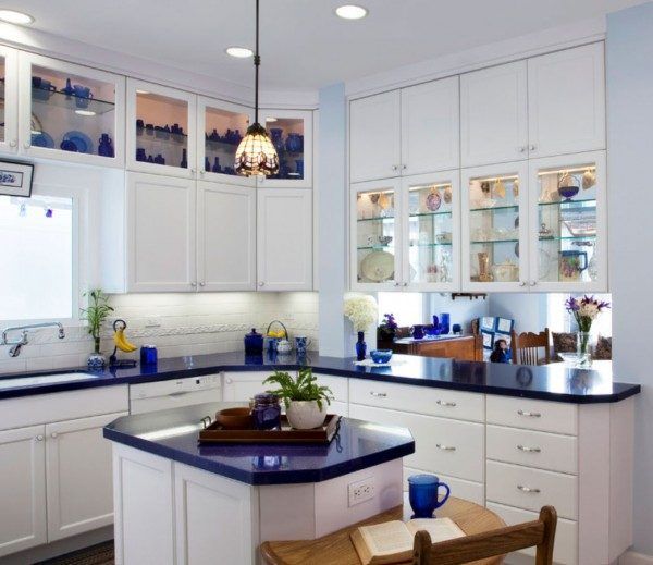 a kitchen with white cabinets and blue counter tops