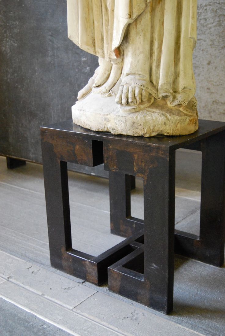 a statue is sitting on top of a small table