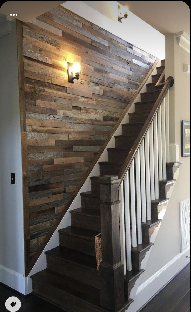 a wooden stair case next to a wall with lights on it and a light in the corner