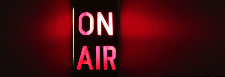 there is a neon sign that says on air in the dark room with red light