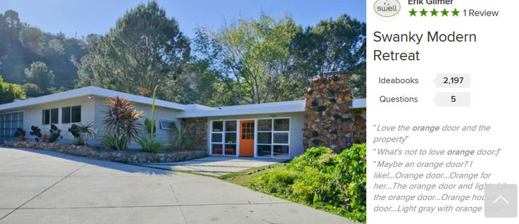 a house that is in the middle of some trees and bushes with an orange door