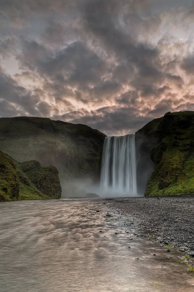 a large waterfall is in the middle of a body of water