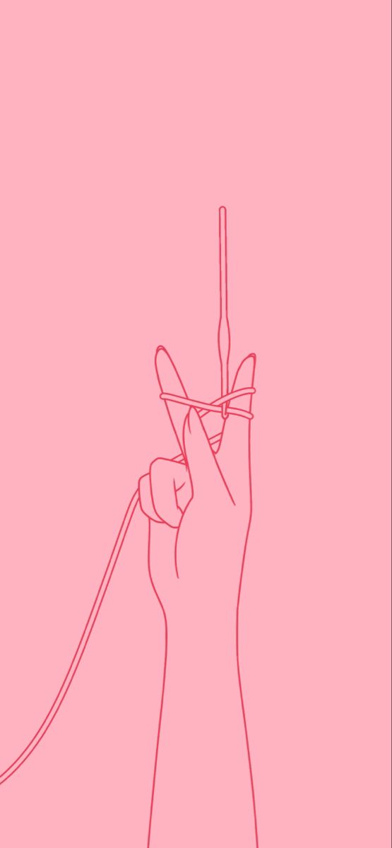 a person's hand holding a string in the shape of a heart on a pink background