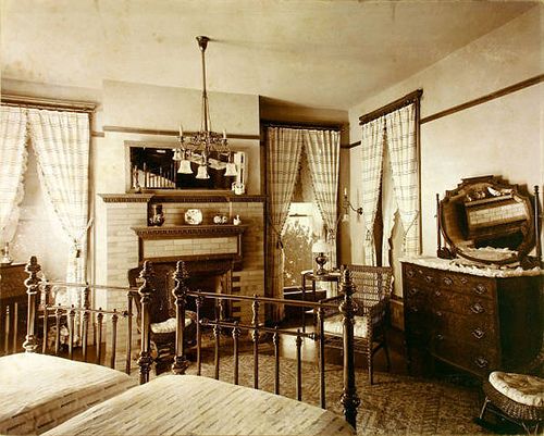 an old photo of a bedroom with a fireplace and bed in the middle of it