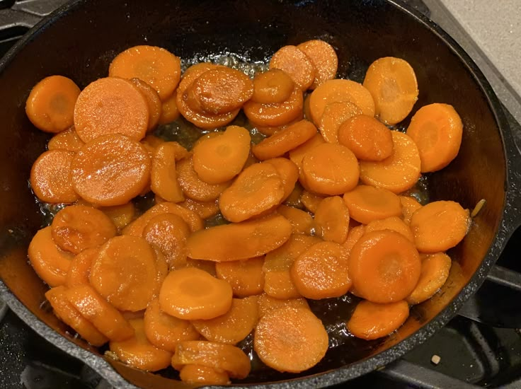 cooked carrots are being cooked in a frying pan