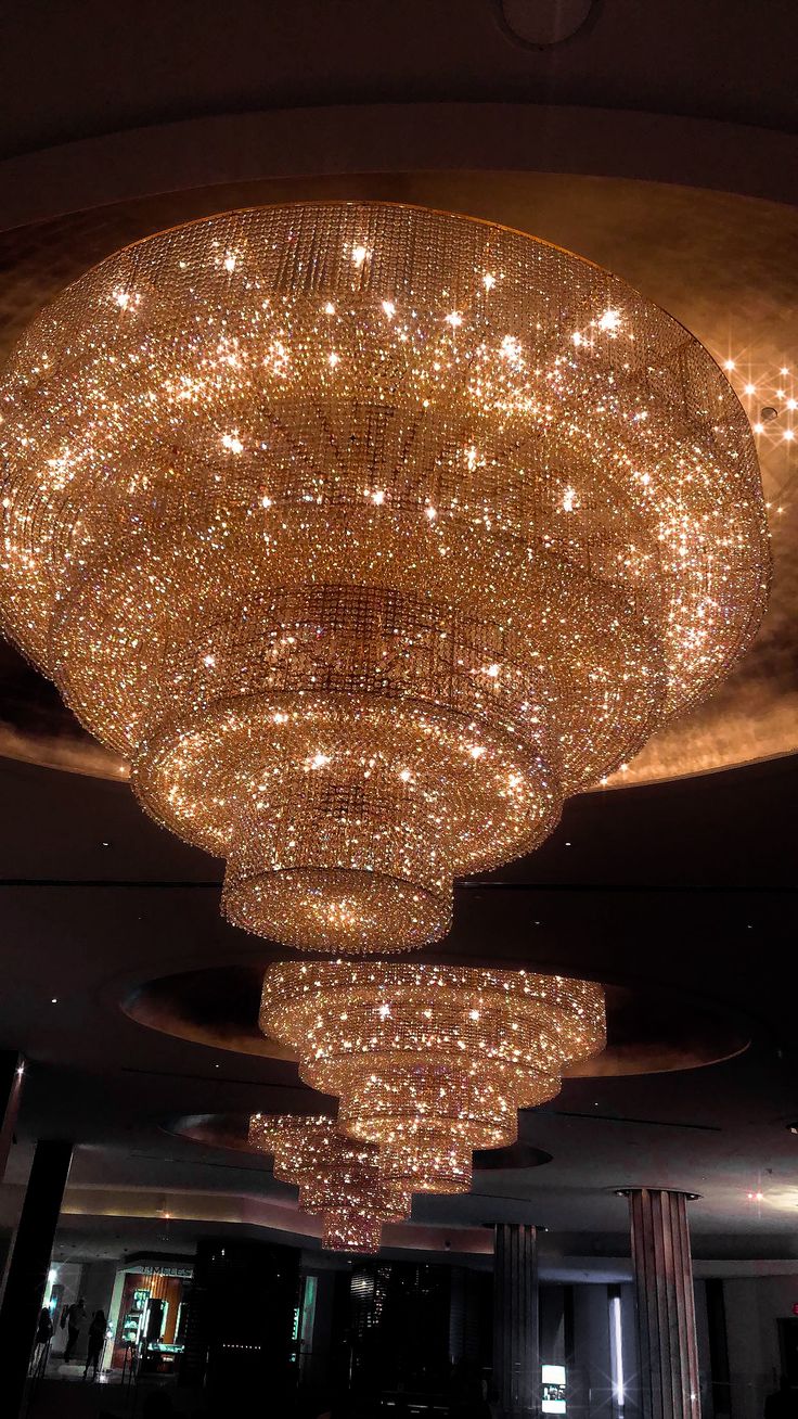 a large chandelier hanging from the ceiling in a room with lights on it