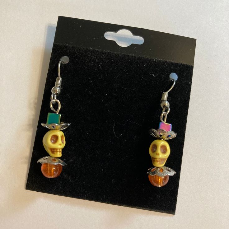 a pair of earrings with yellow and orange beads