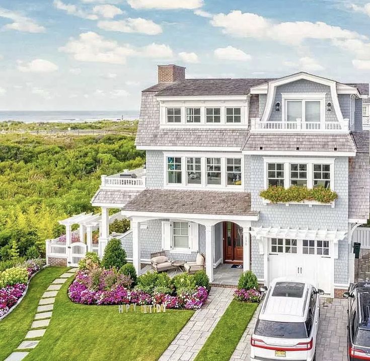 an aerial view of a house with cars parked in the driveway and landscaping around it