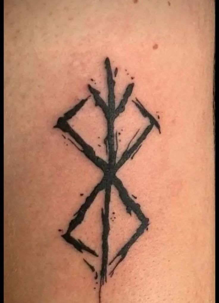 a cross tattoo on the back of a woman's shoulder