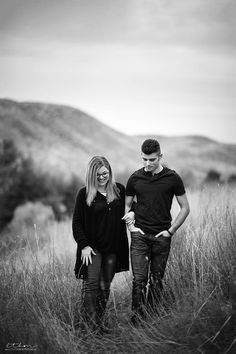 black and white photo of two people standing in tall grass