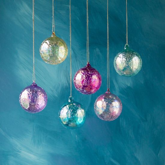 colorful ornaments hanging from strings against a blue background