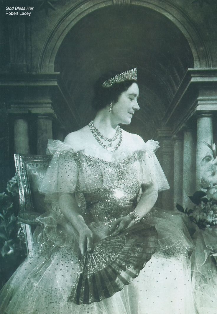 an old black and white photo of a woman wearing a tiara with a fan in her hand