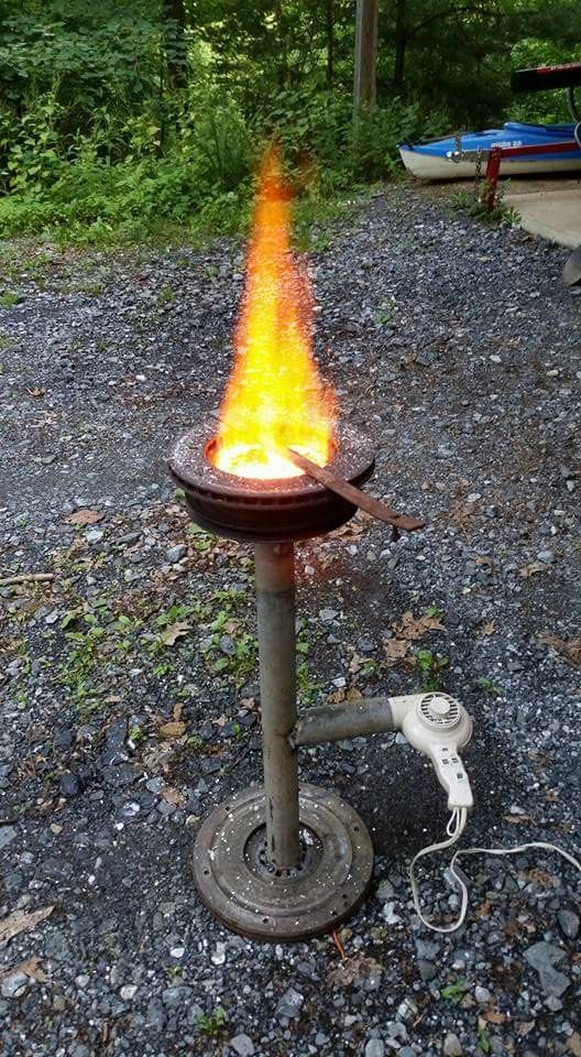 an open fire pit sitting on top of gravel