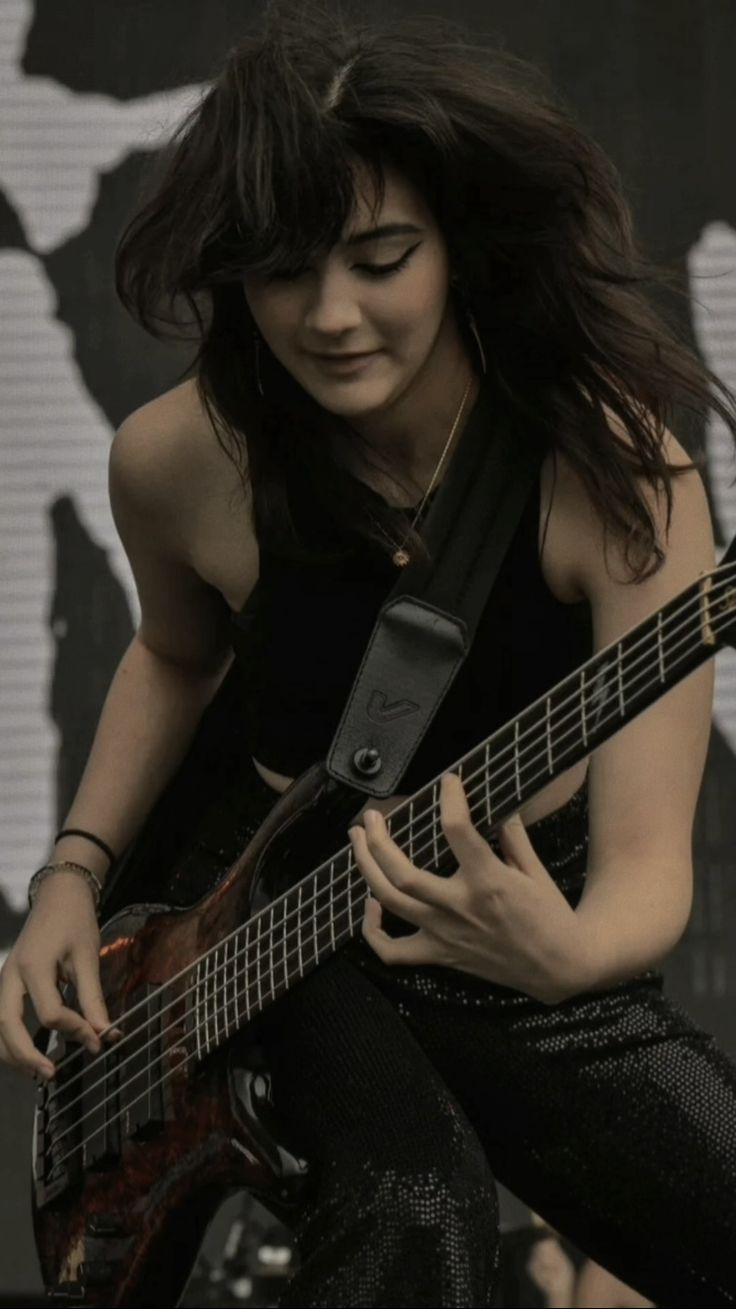 a woman playing an electric guitar on stage