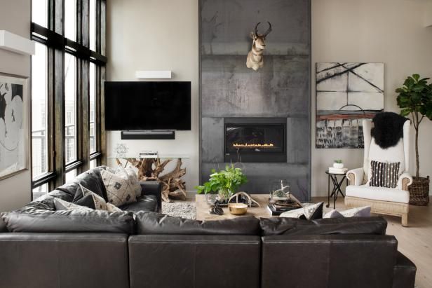 a living room filled with furniture and a flat screen tv mounted on the wall above a fire place