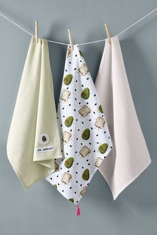 three kitchen towels hanging on a clothes line