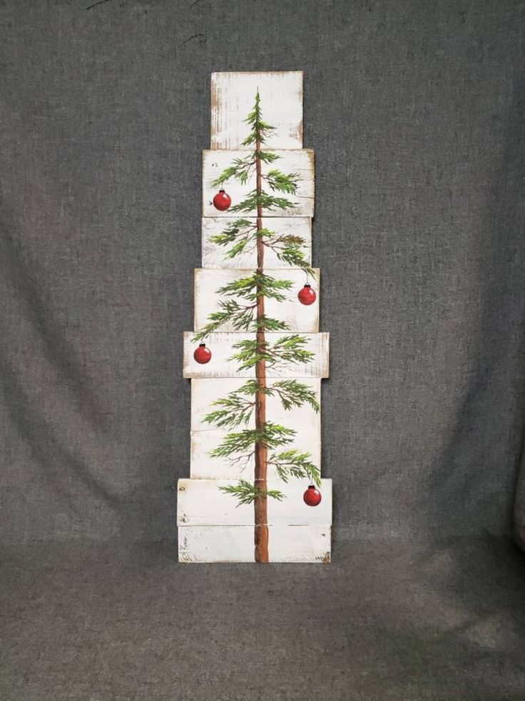 a christmas tree made out of wood with apples on it and pine trees painted on the sides