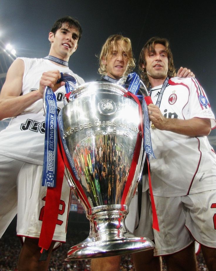 two men standing next to each other in front of a trophy