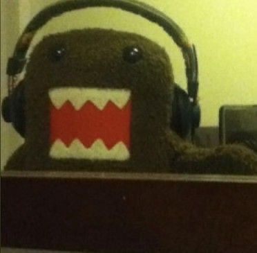 a stuffed animal with headphones on top of a shelf