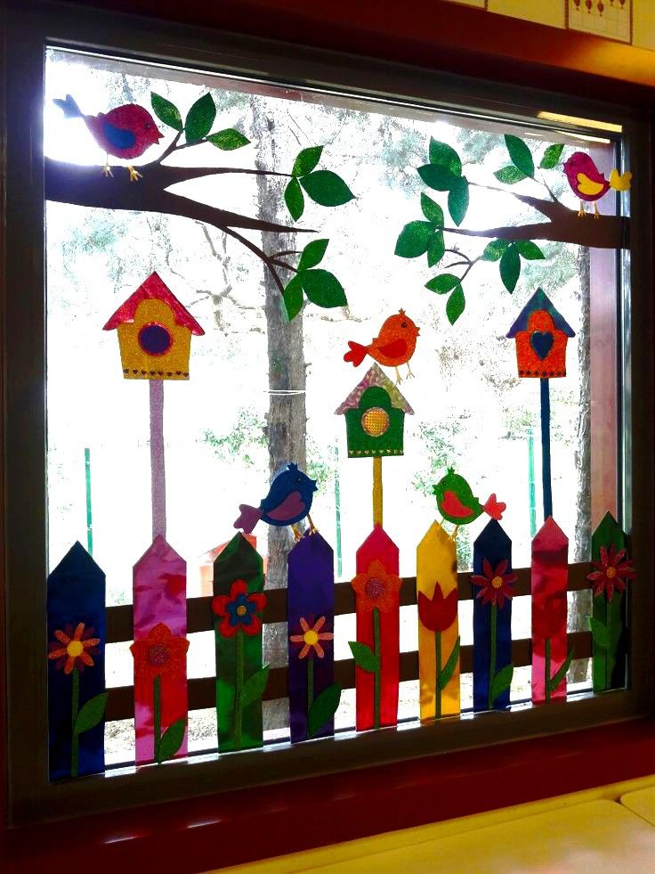 a window decorated with colorful bird houses and trees