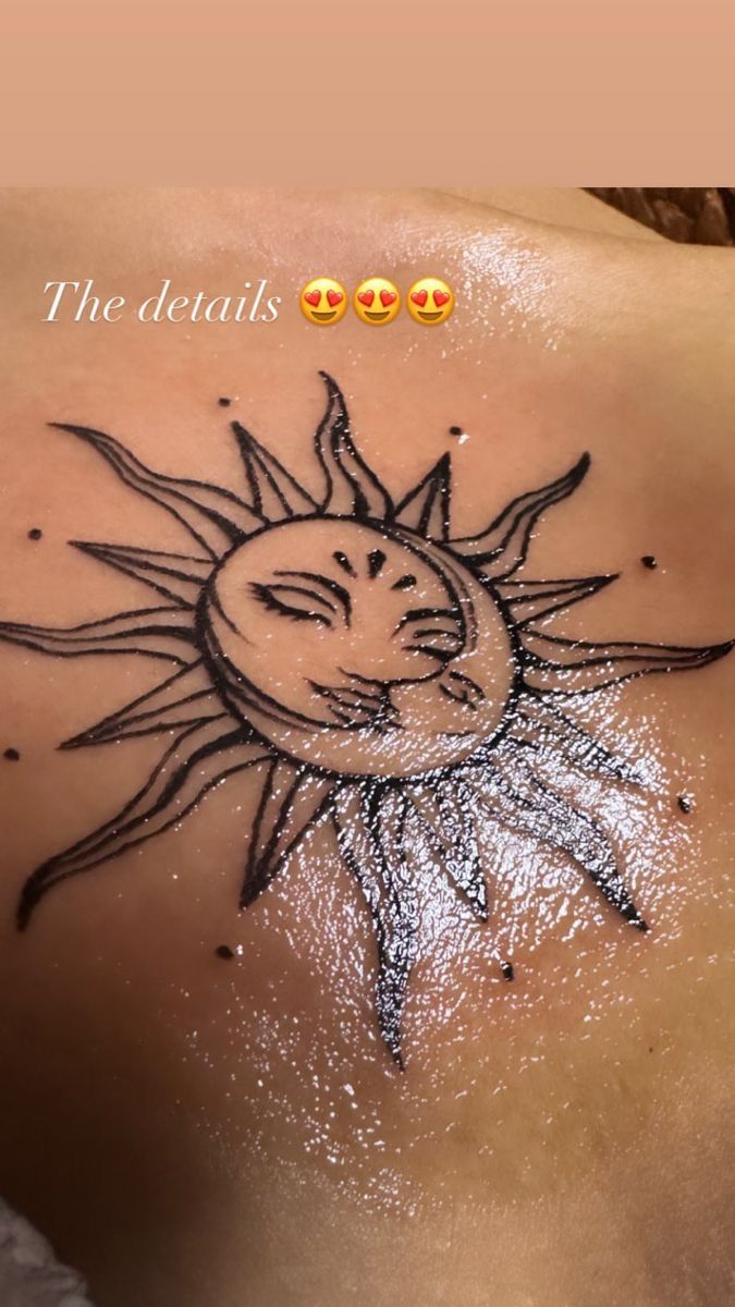 a woman's back with a sun tattoo on it